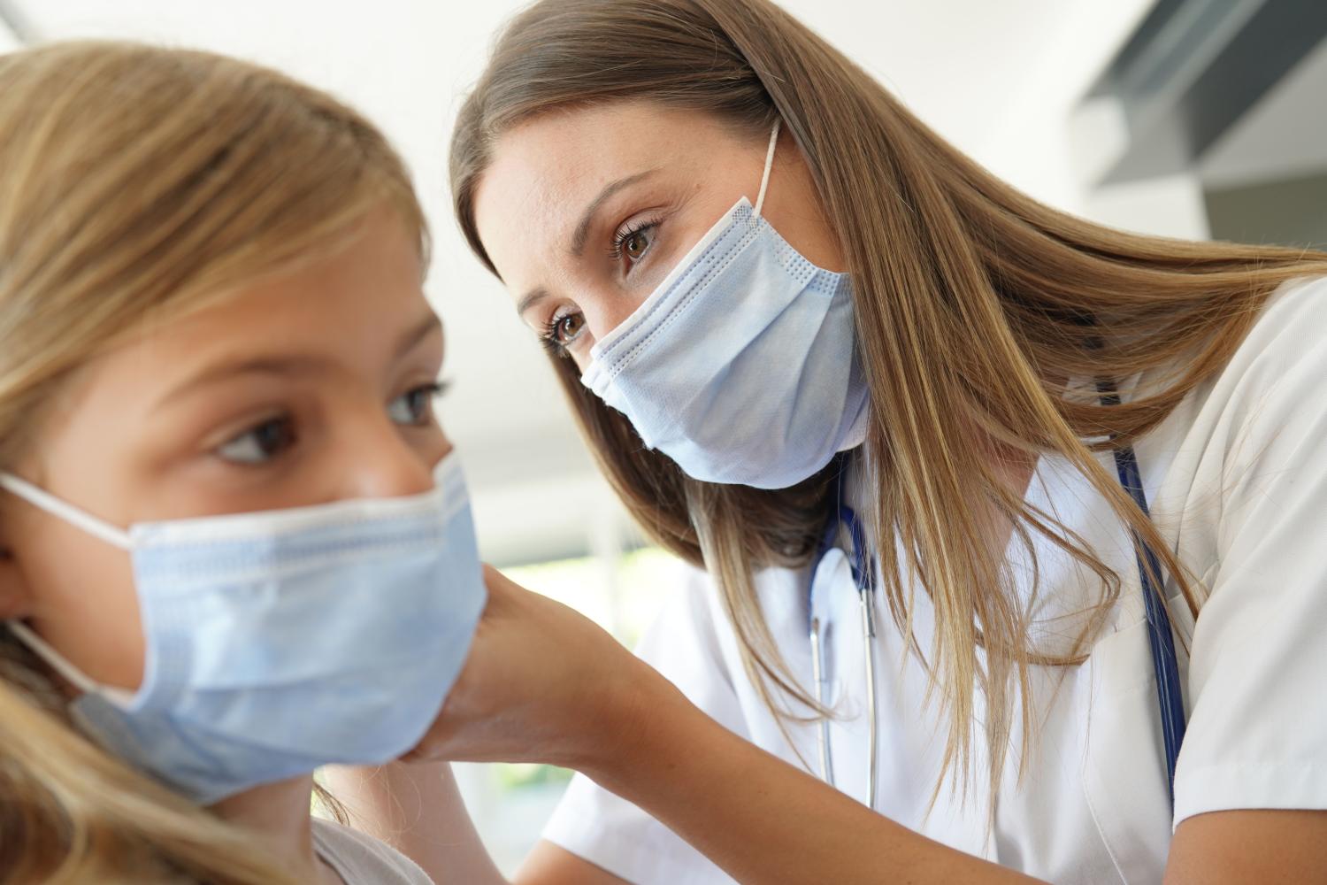 Girl Having Ear Examination by Female Doctor whilst wearing face masks